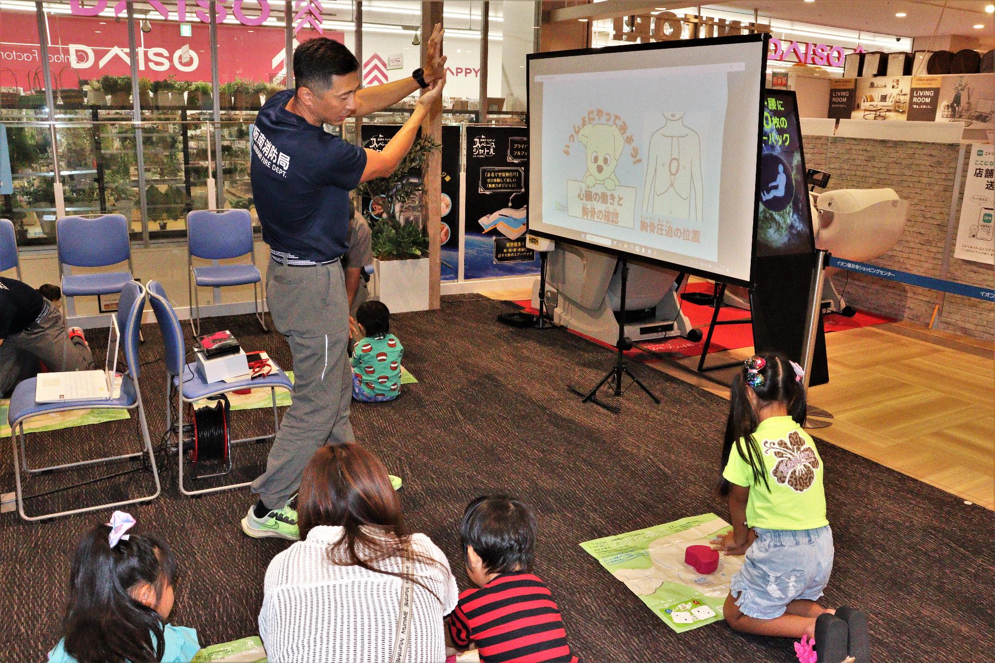 子供たちが胸骨圧迫と模擬のAEDを体験している様子