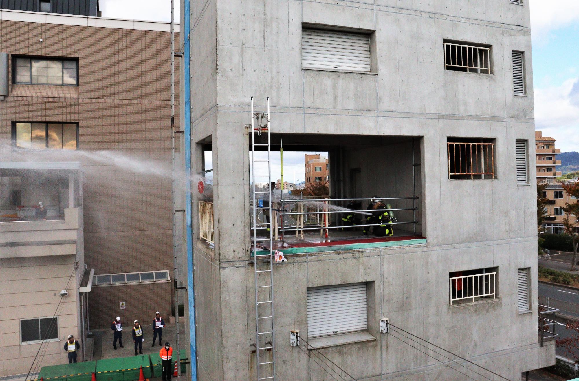 火災建物3階の火災室内で放水している様子