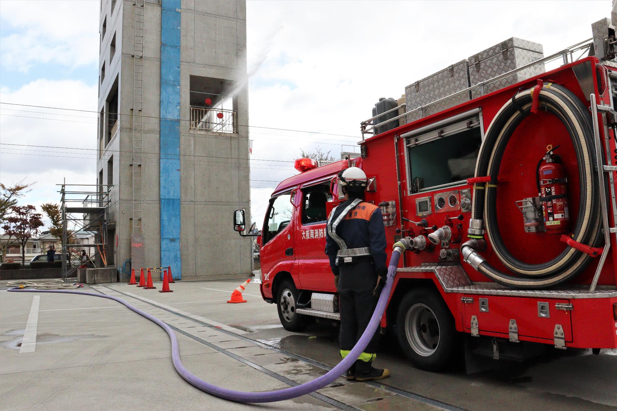 火災建物3階から放水している水柱を地上から見ている様子