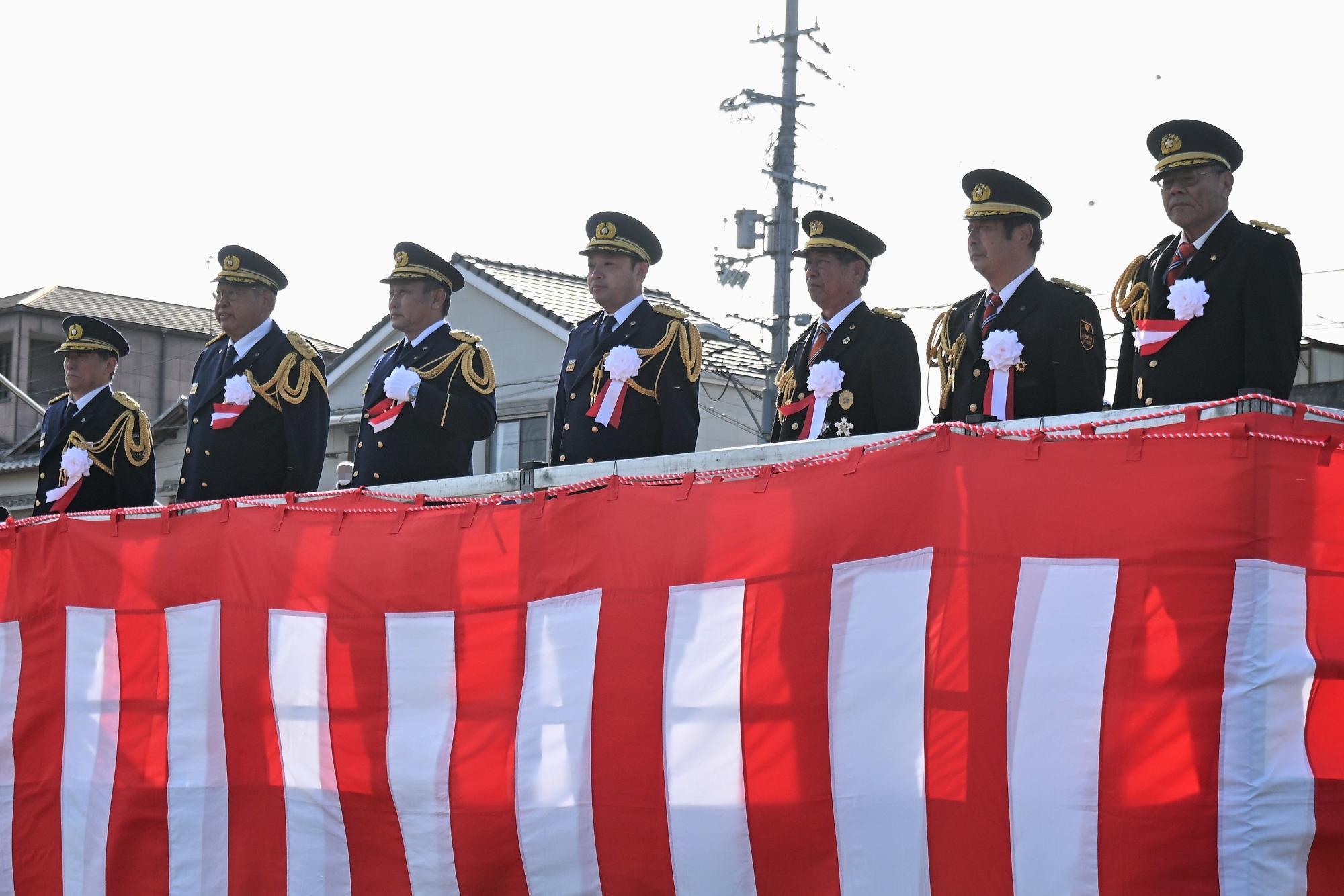 視謁台に登壇した各市の市長と各市の消防団長と消防局長