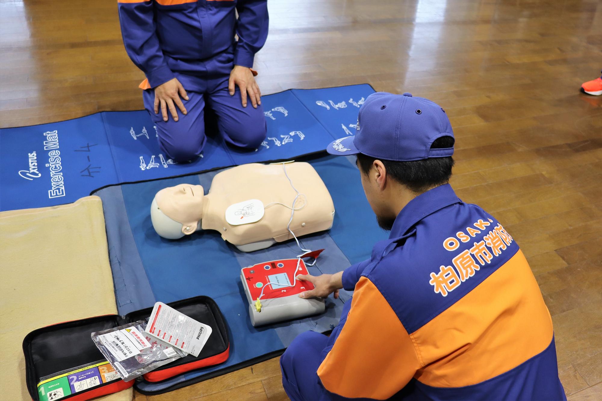 AED（自動体外式除細動器）のショックボタン操作の様子