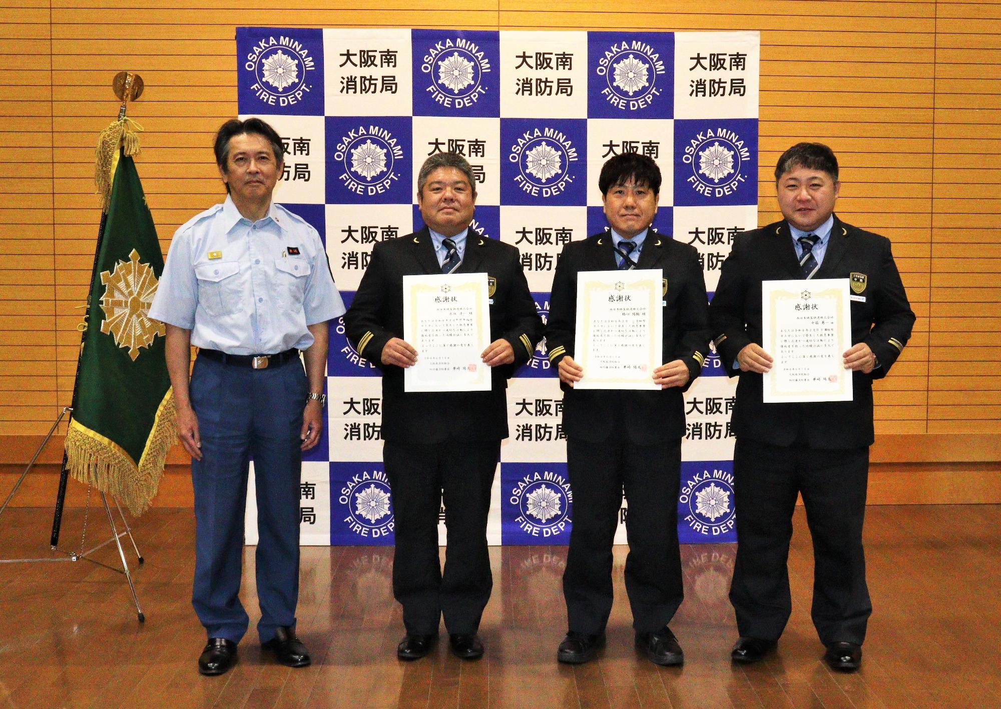 表彰者3名と消防署長の記念撮影の様子