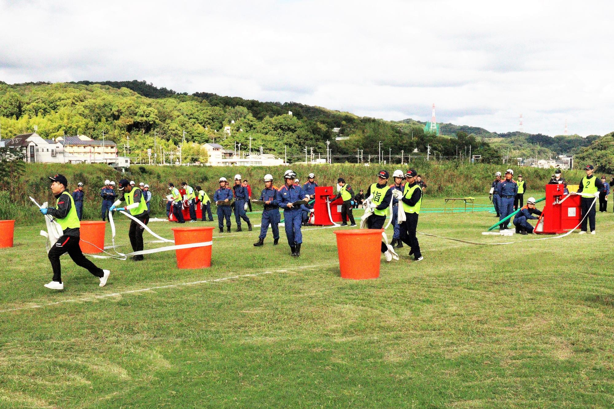 屋内消火栓から消防ホースを障害を避けながら延ばしている風景