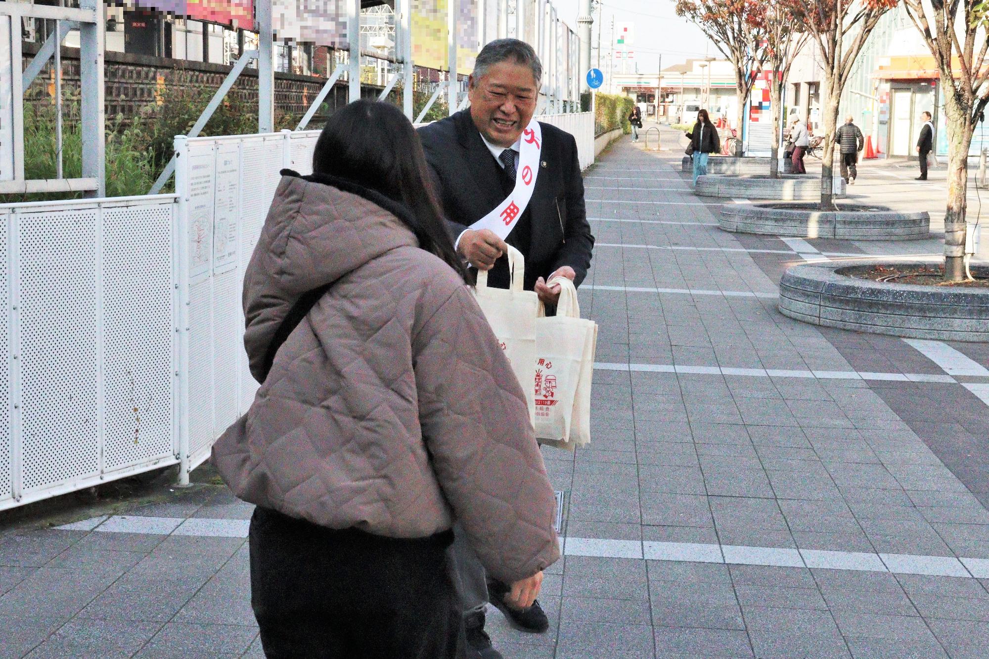 藤井寺駅前にて藤井寺市長による火災予防啓発グッズの配布の様子