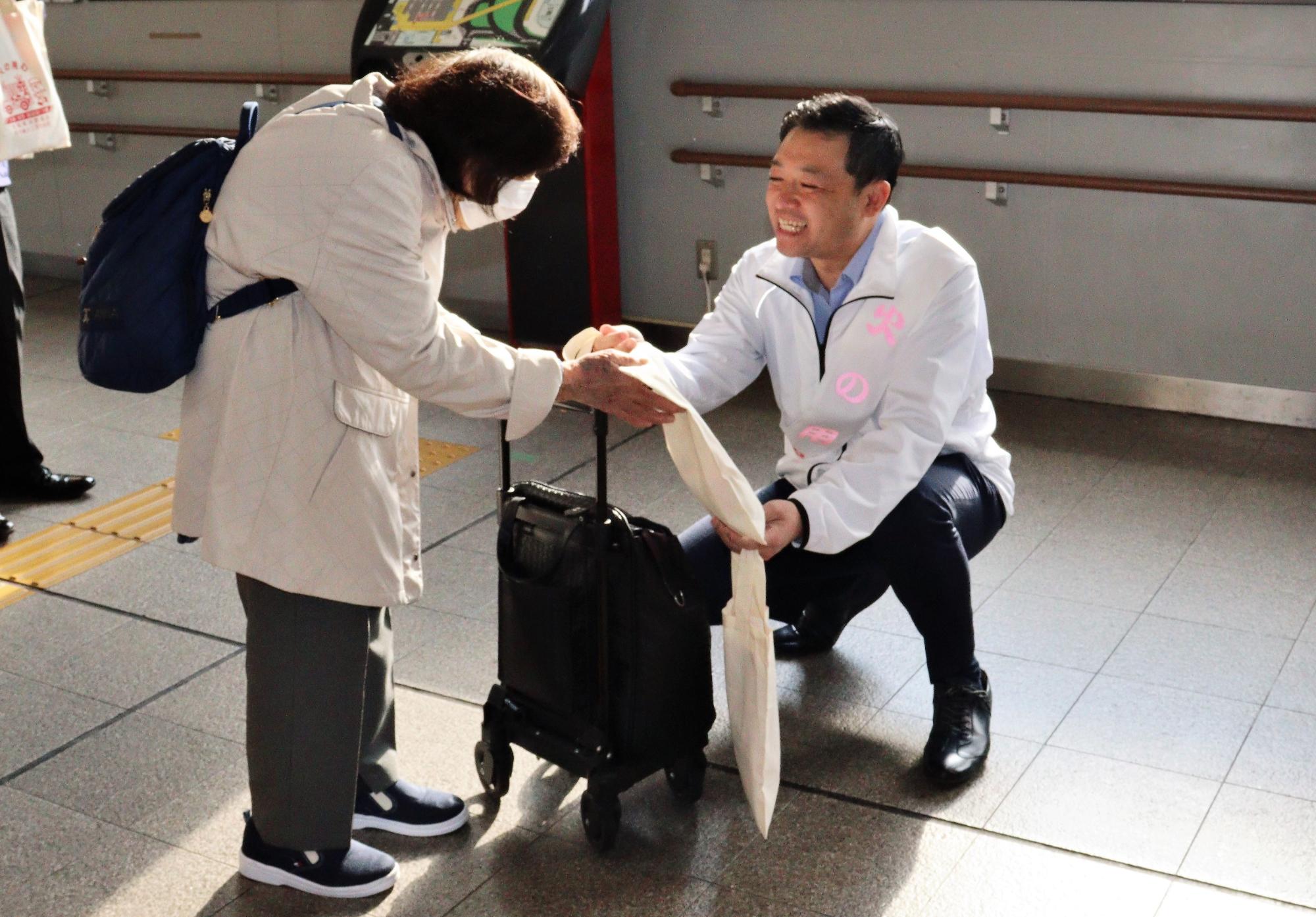 柏原駅構内にて柏原市長による火災予防啓発グッズの配布の様子